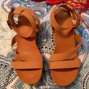Tan sandals wrap around ankle buckle.